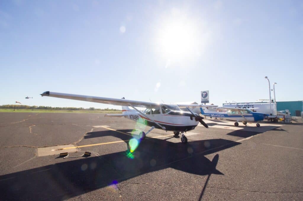 The Cessna 172 N784BG on the ramp at KSUW, the fuel farm and a second Cessna behind it.
